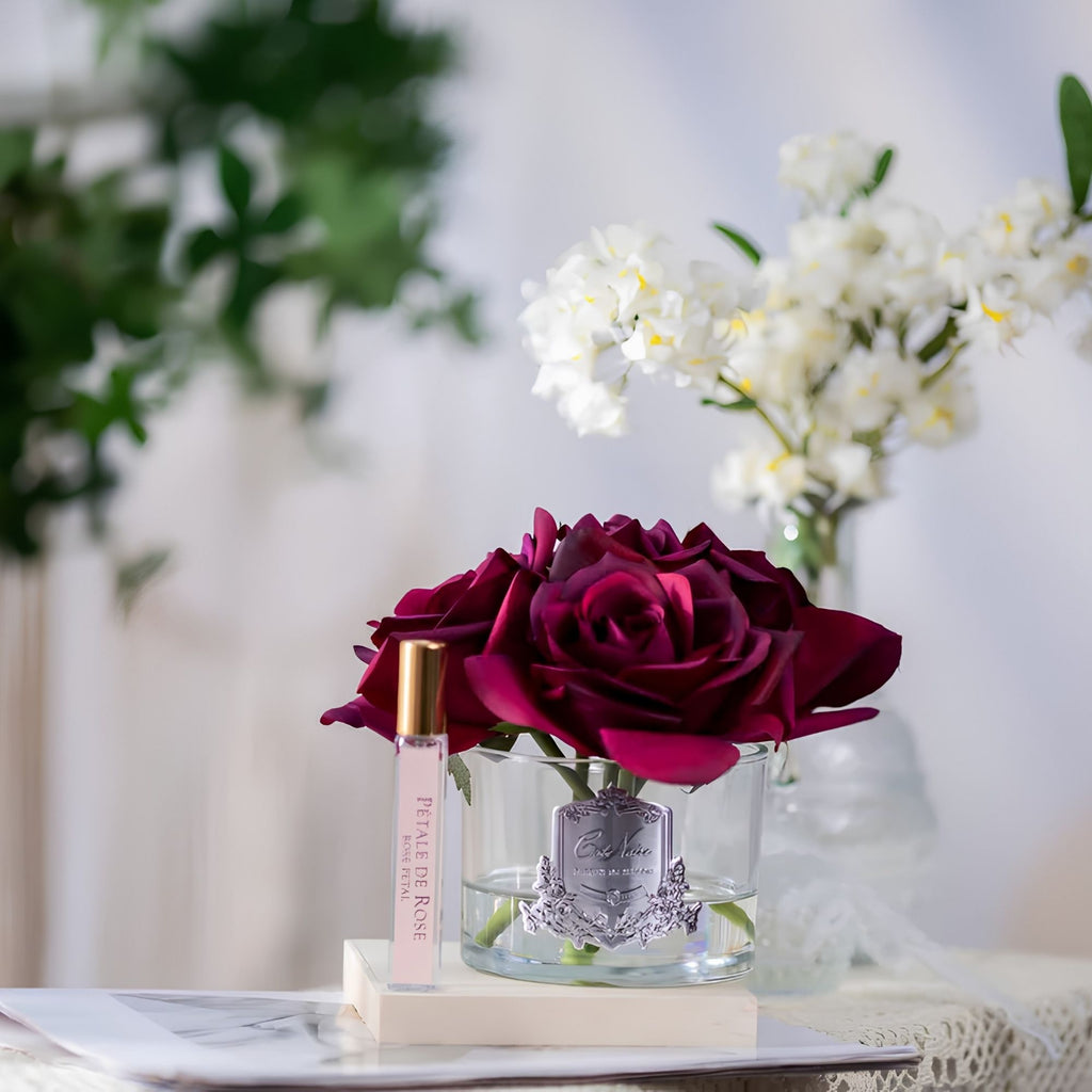 Close-up of Côte Noire Five Roses red petals in clear gel with silver badge detail