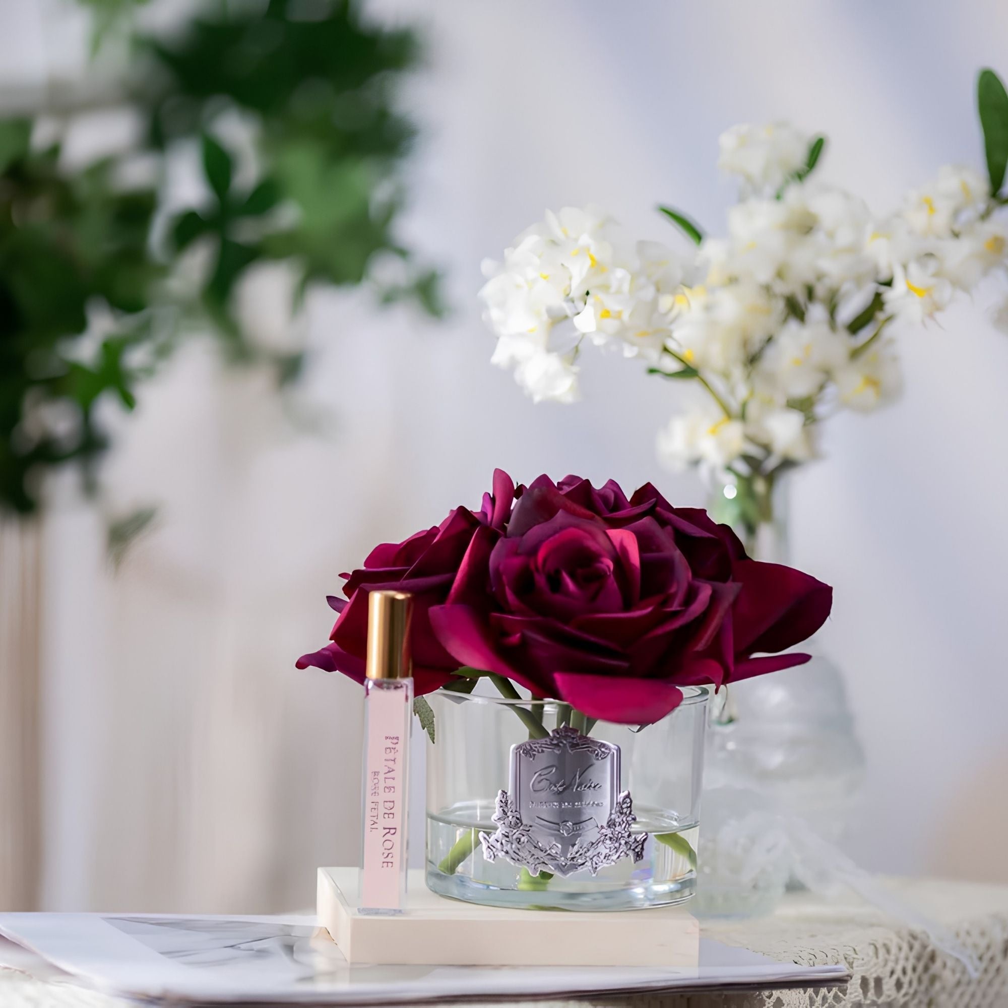Close-up of Côte Noire Five Roses red petals in clear gel with silver badge detail