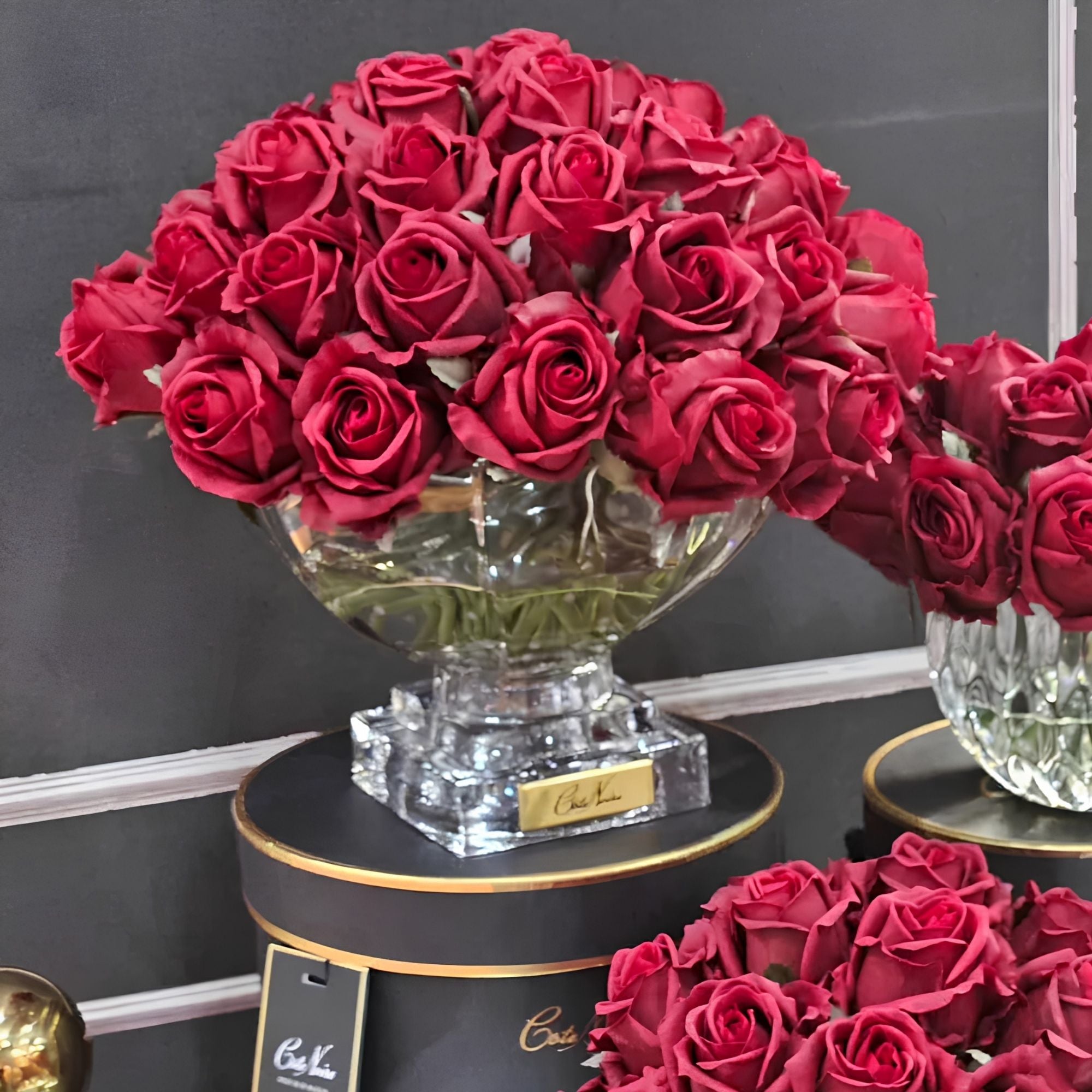 Close-up of Côte Noire Luxury Centrepiece Red rose buds in crystal-clear gel with gold badge detail