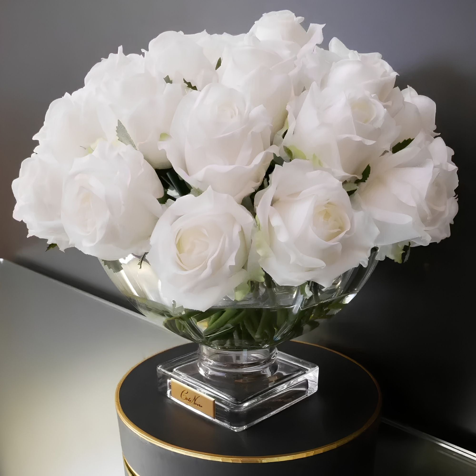 Close-up of Côte Noire Luxury Centrepiece White rose buds in crystal-clear gel with gold badge detail